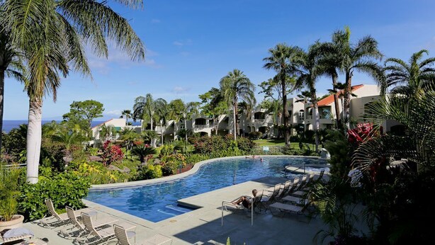 A pool area with lounge chairs, palm trees, and a view of the ocean. - Palms at Wailea #205 Fully Remodeled, Ground Floor Unit, Shared Hot Tub, A/C (Wailea)