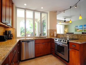 Enjoy cooking in this well-equipped kitchen with a dishwasher, oven, and wooden cabinets.