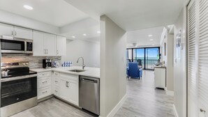 A modern kitchen with white cabinets, stainless steel appliances, and a dishwasher. - SUNDIAL A306 - Direct Beachfront Sanibel Condo (Sanibel)