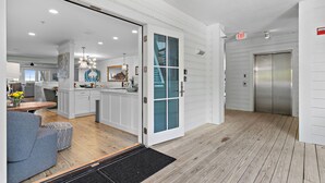 A modern interior with a kitchen, dining area, and an elevator.