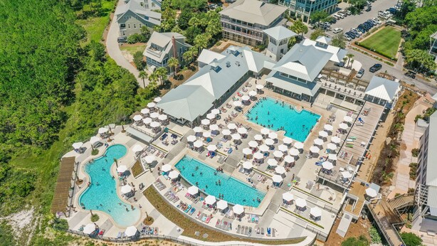 A resort with multiple swimming pools, sun umbrellas, and a well-maintained landscape.