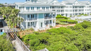 A large, multi-story hotel with a white exterior, multiple balconies, and lush landscaping.