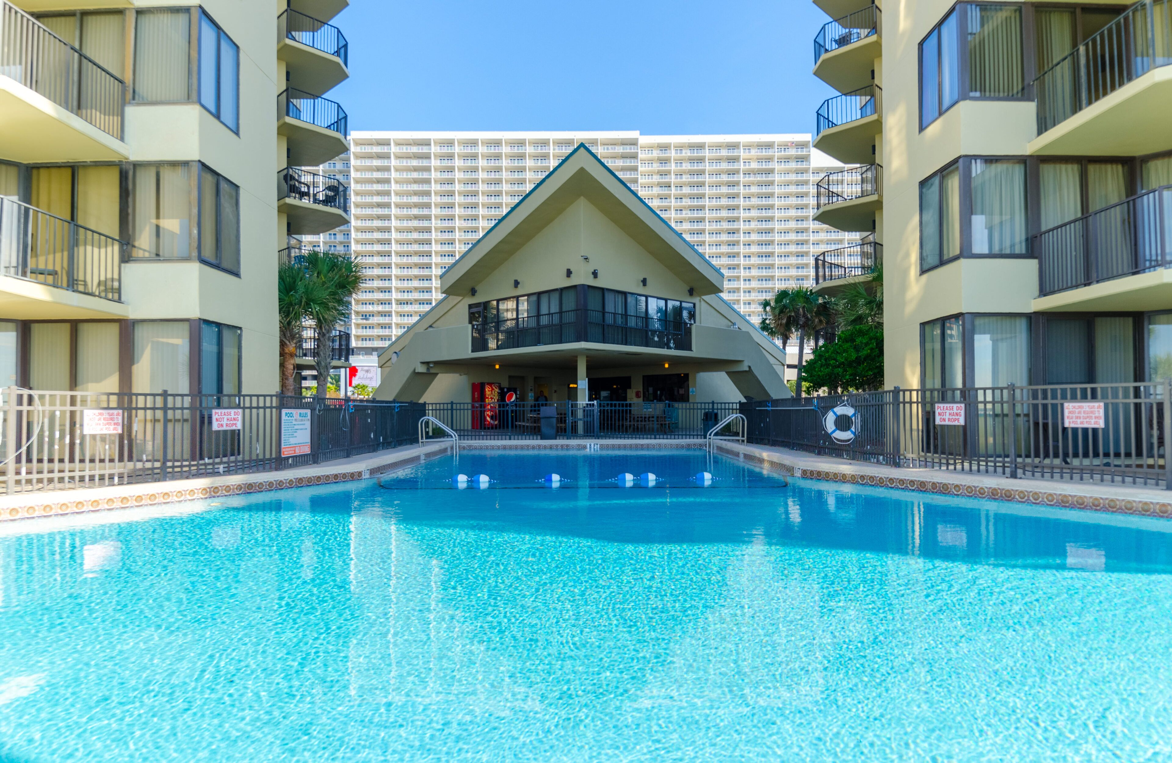 Piscina com um edifício ao fundo.