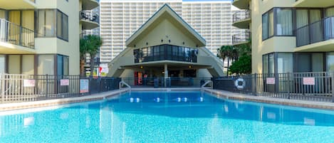 Piscina com um edifício ao fundo.