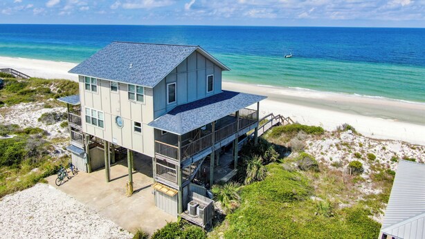 A beachfront house with a balcony, a covered porch, and a view of the ocean. - Large 5 bedroom, 3-1/2 bath BEACHFRONT Home, Just Steps to Peaceful Beach (Port Saint Joe)
