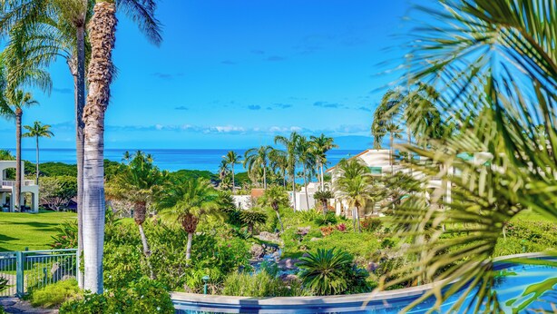 A resort with a pool, palm trees, and a view of the ocean. - Palms at Wailea #1105 Lovely Ocean View, Near Complex Pool and Shared Hot Tub (Wailea)