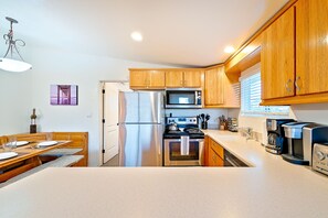 Compact kitchen with a dining table and modern appliances.