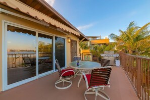 Enjoy al fresco dining with a round table and four chairs, barbecue grill, and ocean views.