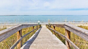A wooden boardwalk leading to a beach with a clear view of the water and sky. - Bay View Villas 203 | Waterfront, Community Pool (Tybee Island)