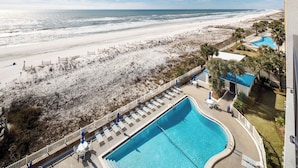 A resort with a swimming pool, beach access, and a view of the ocean.