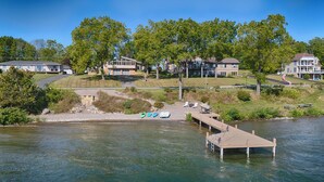 Une propriété au bord du lac, avec un quai, des bateaux et des maisons en arrière-plan.