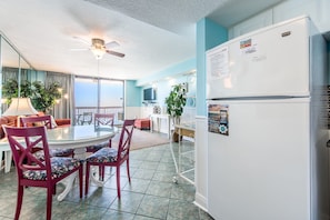 Un espacio habitable compacto con comedor, refrigerador y ventilador de techo.