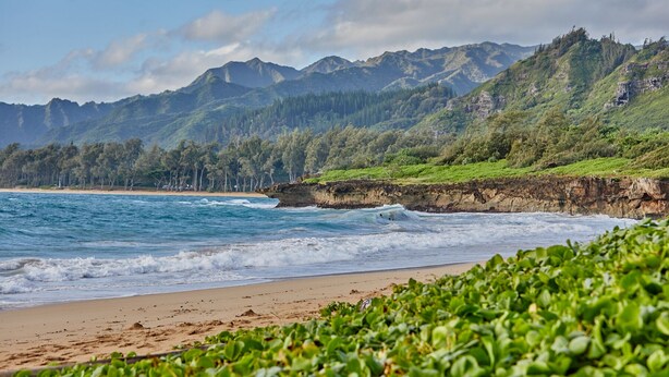A beach with waves, a forested mountain, and a clear sky. - Hawaiian plantation-style home, perfect for families.  (Hauula)