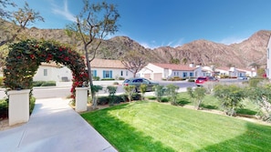 A residential area with houses, a driveway, and a mountain backdrop.