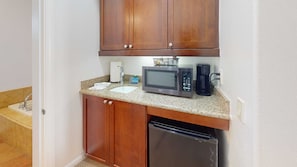 A compact kitchen with a microwave, coffee maker, and dishwasher.