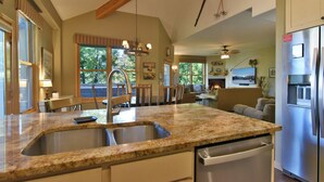 A kitchen with granite countertops, stainless steel appliances, and a large window. - Corral at Breckenridge Raven Condo: Soaking Tub, Views (Breckenridge)
