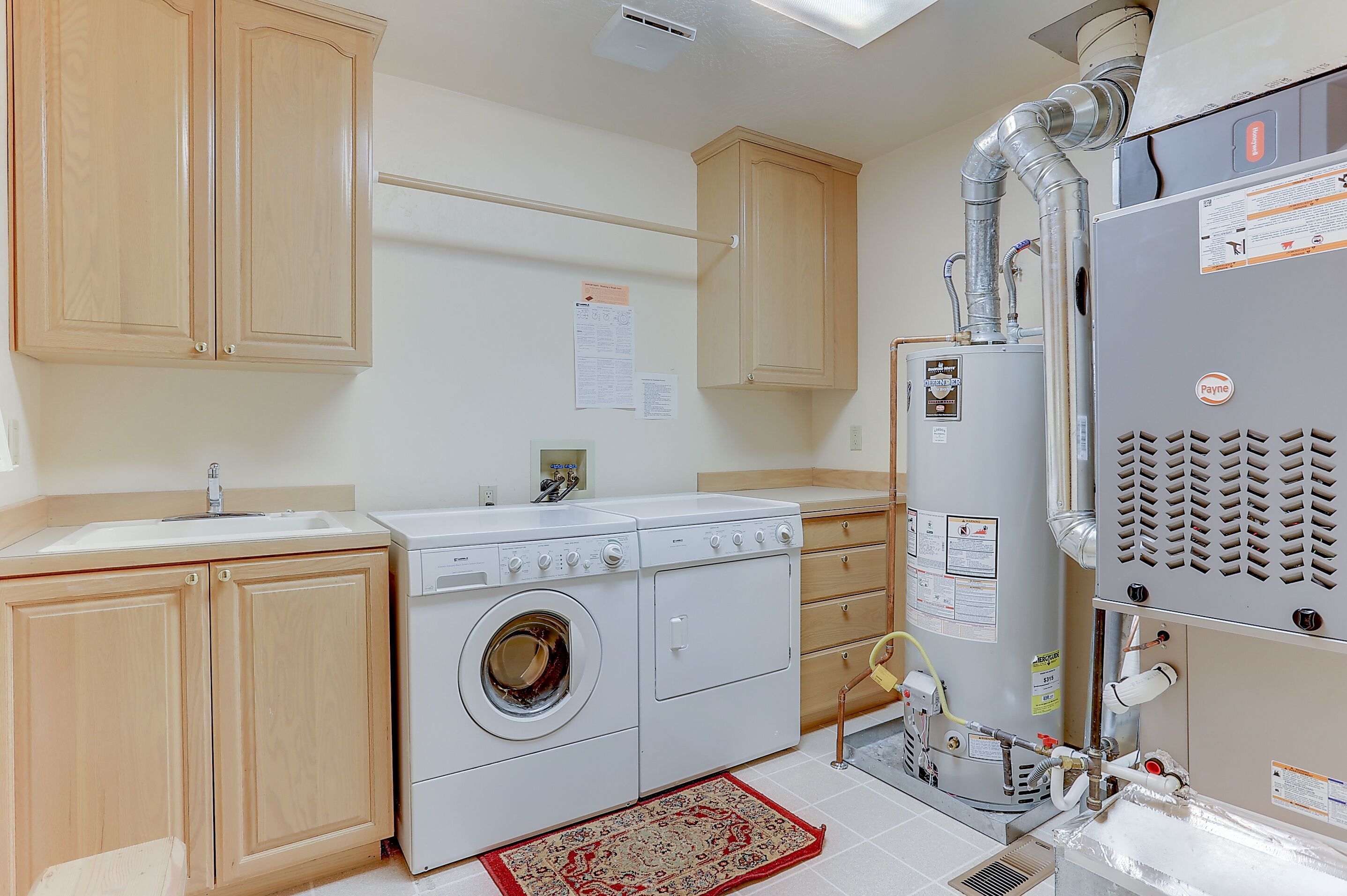 A laundry room with a washing machine, dryer, and a water heater.