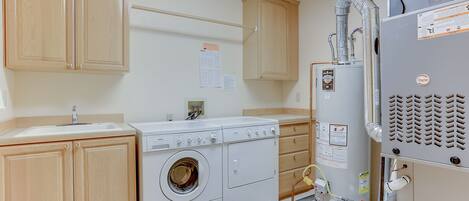 A laundry room with a washing machine, dryer, and a water heater.