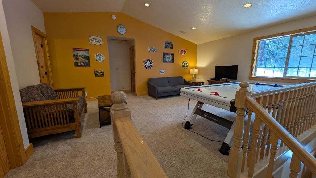 A cozy living room with a pool table, a sofa, and a wooden bench.