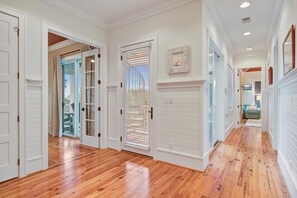 Stunning hallway with polished floors and a glass door leading to an outdoor area.