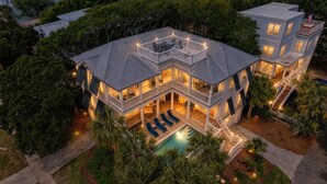 Uma casa com vários andares, piscina, varandas e áreas de estar ao ar livre.
