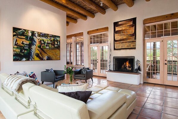 A spacious living area with a fireplace, leather sofas, and a large painting. - Casa Bonita Ribera (Santa Fe)