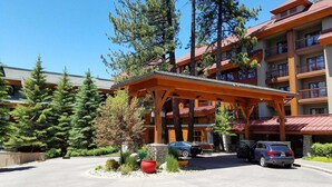 A multi-story building with a wooden structure, a covered entrance, and a parking area with cars. - Marriott Grand Res #4256 - Next door to Heavenly Gondola - Large Studio - Gondola View (South Lake Tahoe)