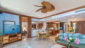 Un salón amplio con televisor, mesa de comedor y asientos.