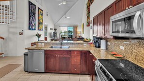 Een moderne keuken met een centraal eiland, roestvrijstalen apparatuur en houten keukenkastjes.