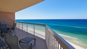 Un balcon avec vue sur l’océan, aménagé avec des chaises et une table.