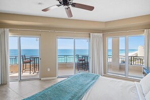 Relax in this serene hotel room with a large bed and sliding glass door leading to a balcony overlooking the ocean and city views.