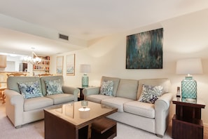 A living room with two sofas, a coffee table, and a bookshelf.