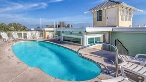 A swimming pool with lounge chairs and a lifeguard tower. - Captains Watch 11 | Rooftop Pool, 1 Block to Beach (Tybee Island)