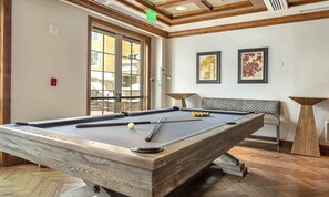 Enjoy a game of pool in a stylish room with a pool table, bench, and artwork.