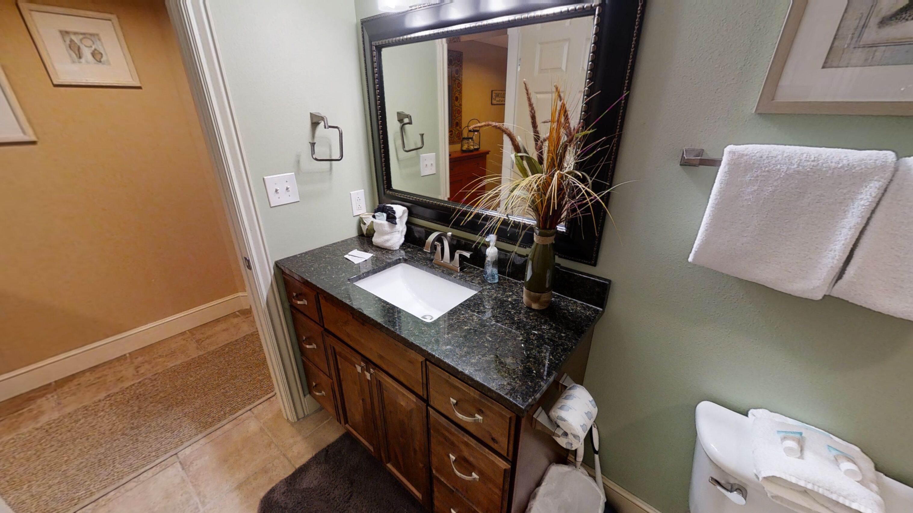 A bathroom with a sink, mirror, and towel rack.