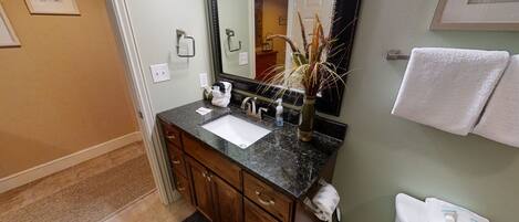 A bathroom with a sink, mirror, and towel rack.