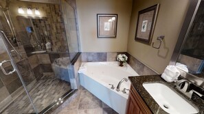 Une salle de bain moderne avec une douche à parois de verre, une baignoire sur pieds, un lavabo et un miroir.