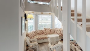 A cozy room with a sofa, two chairs, a small table, and a staircase. - Beautiful villa with lake views and a floating dock!  271F (Miramar Beach)