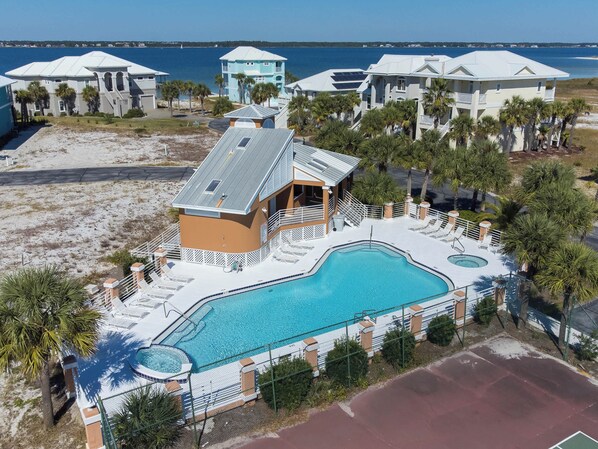 Ein Resort mit großem Pool, mehreren Gebäuden und Blick auf den Ozean.