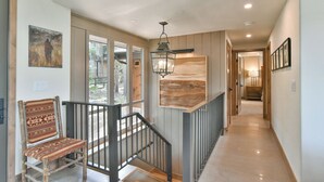 A hallway with a wooden chair, a hanging lantern, and a view of the outdoors. - Lonestar Lodge: Sweeping Mountain Views, Hot Tub & Patio (Breckenridge)