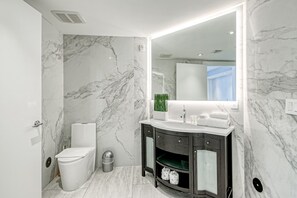 Une salle de bain moderne avec des toilettes, un meuble-lavabo et un grand miroir.