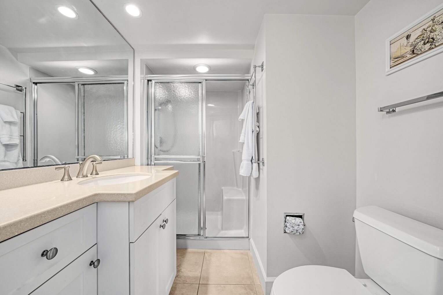 A modern bathroom with a shower, toilet, and sink.