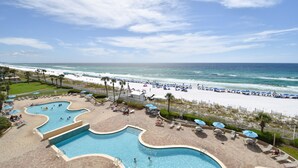 Un resort con una piscina grande, acceso a la playa y vista al océano.