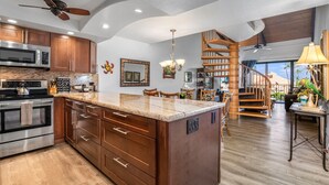 A spacious kitchen with wooden cabinets, a large island, and a built-in microwave.