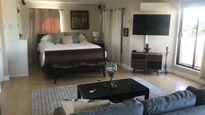 Ein Schlafzimmer mit Bett, Nachttisch, Lampe und Fernseher.