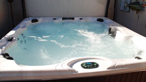 Ein Whirlpool mit Bedienfeld, umgeben von einer Holzterrasse.