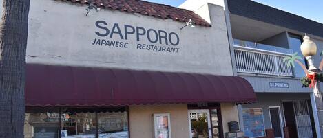 A Japanese restaurant named Sapporo with a stone facade and a red awning.