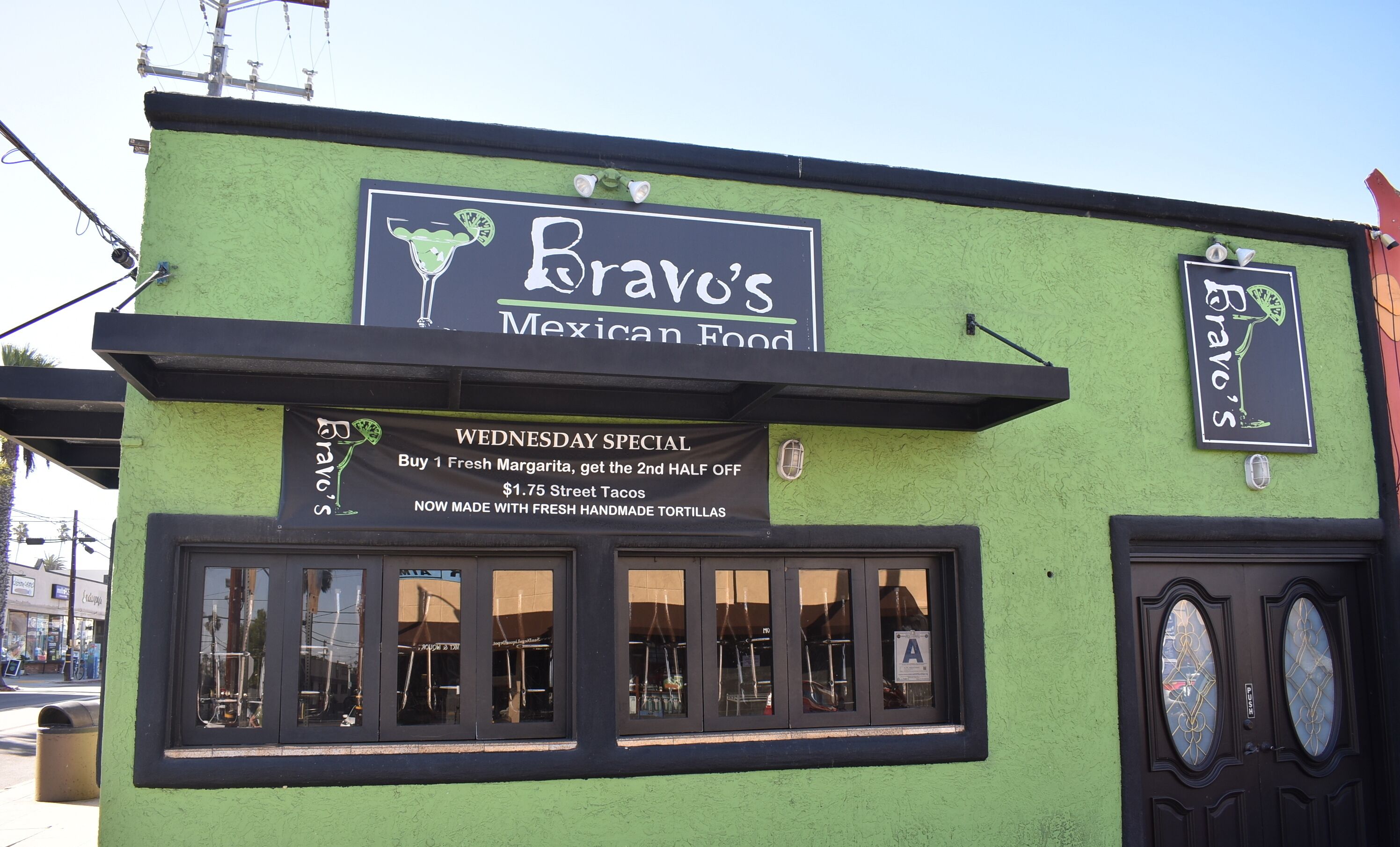Un edificio verde con un'insegna per Bravos Mexican Food, che offre un'offerta speciale per mercoledì.