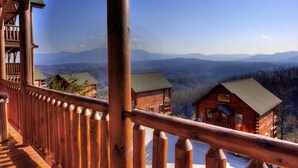 Eine Holzhütte mit Balkon mit Blick auf eine gebirgige Landschaft.
