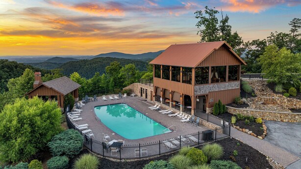 Ein Resort mit Pool, Liegestühlen und Bergblick.